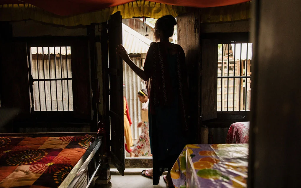 Farah, a child marriage survivor, is looking outside her home in Bangladesh.
